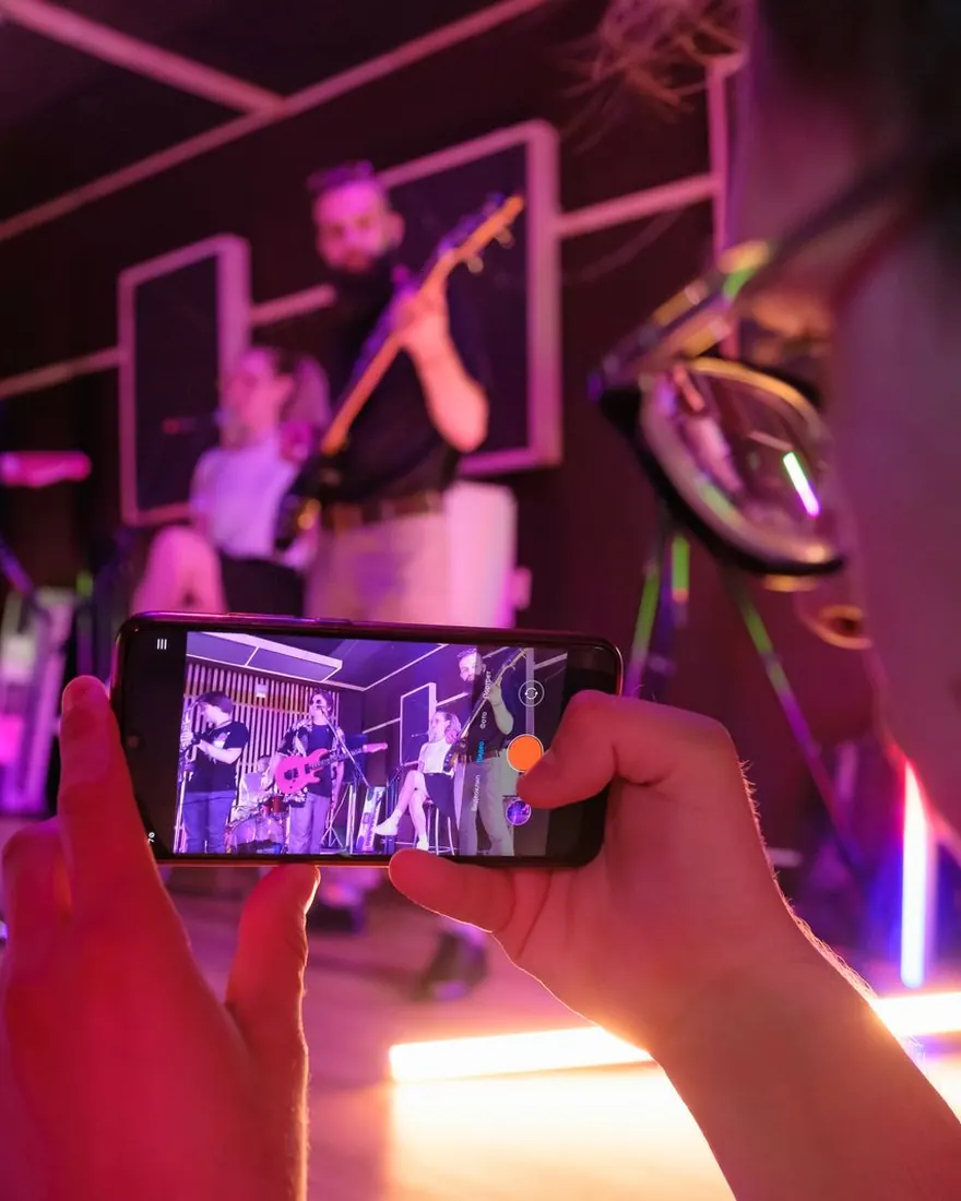 Un groupe filmé en live au téléphone, tenu à deux mains